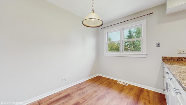 4265 Portage Ln, Hoffman Estates, IL 60192 - unfurnished dining area with baseboards and light wood-type flooring