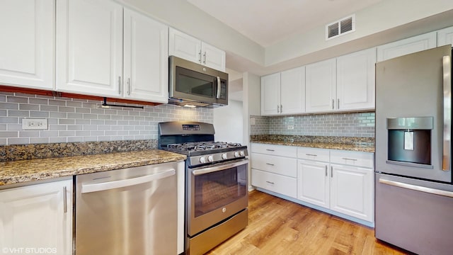 4265 Portage Ln, Hoffman Estates, IL 60192 - kitchen with appliances with stainless steel finishes, light wood-style flooring, white cabinetry, and light stone counters