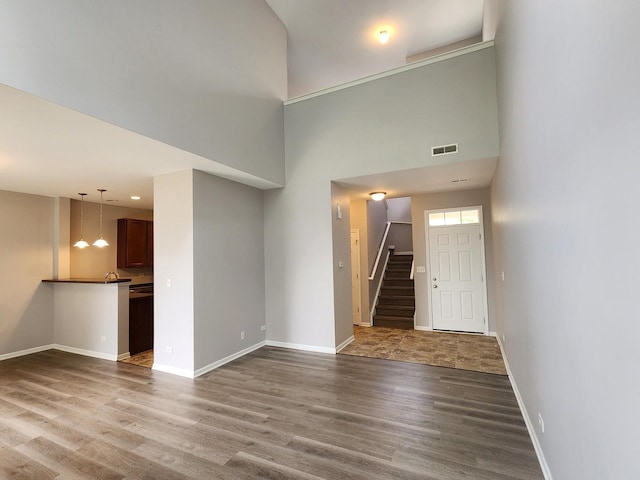 3169 Pearl St, Elgin, IL 60124 - unfurnished living room featuring dark wood-style flooring, stairs, and a high ceiling