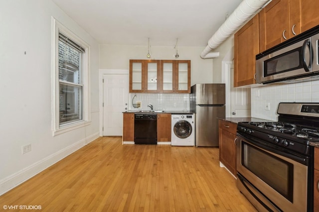 1729 W Erie St Unit 3N, Chicago, IL 60622 - kitchen featuring stainless steel appliances, washer / clothes dryer, backsplash, light wood finished floors, and glass insert cabinets