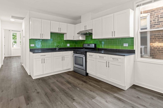 2507 W 45th Pl, Chicago, IL 60632 - kitchen with stainless steel gas stove, under cabinet range hood, white cabinetry, and dark countertops