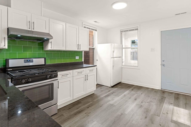 2507 W 45th Pl, Chicago, IL 60632 - kitchen featuring freestanding refrigerator, stainless steel gas range oven, under cabinet range hood, light wood-type flooring, and white cabinetry