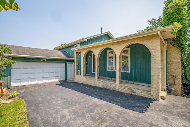 294 Apache Trl, Lake In The Hills, IL 60156 - view of front of home with covered porch, driveway, a garage, and brick siding