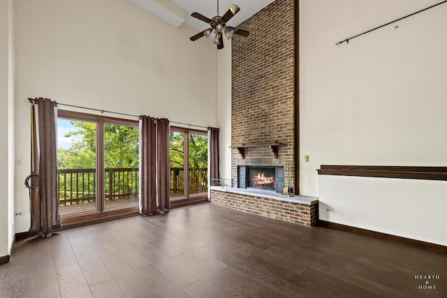 294 Apache Trl, Lake In The Hills, IL 60156 - unfurnished living room with a high ceiling, wood finished floors, a ceiling fan, and a brick fireplace