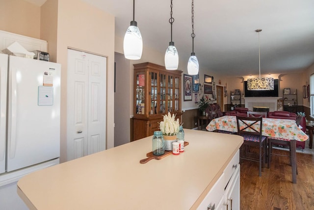 85 Fieldstone Dr, Lake Villa, IL 60046 - kitchen with freestanding refrigerator, white cabinets, a fireplace, light countertops, and wood finished floors