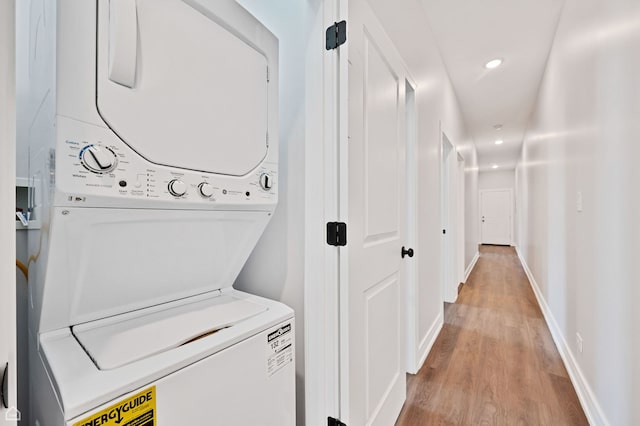 4435 S Prairie Ave, Chicago, IL 60653 - washroom featuring stacked washing machine and dryer, light wood-type flooring, and recessed lighting