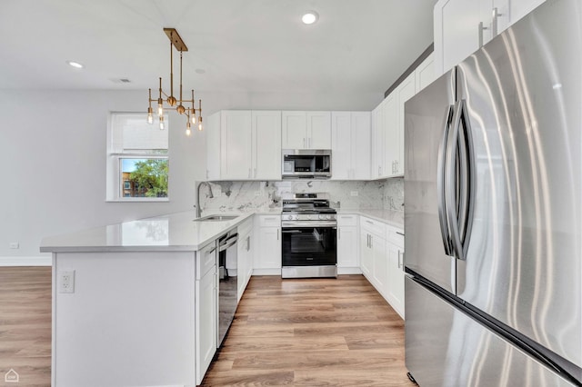 4435 S Prairie Ave, Chicago, IL 60653 - kitchen featuring stainless steel appliances, backsplash, light wood-style flooring, light countertops, and recessed lighting