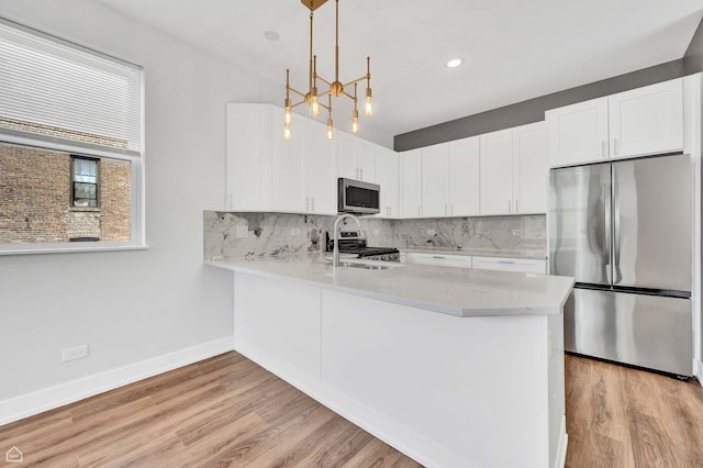 4435 S Prairie Ave, Chicago, IL 60653 - kitchen featuring appliances with stainless steel finishes, light countertops, backsplash, and a peninsula