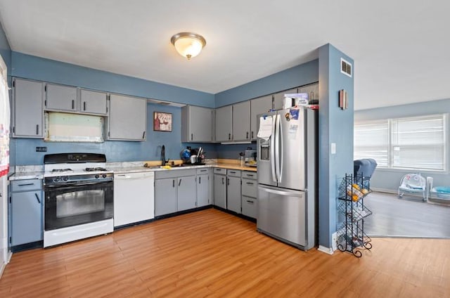 1311 Juneway Ter, Round Lake Beach, IL 60073 - kitchen featuring white appliances, light wood finished floors, gray cabinets, and light countertops