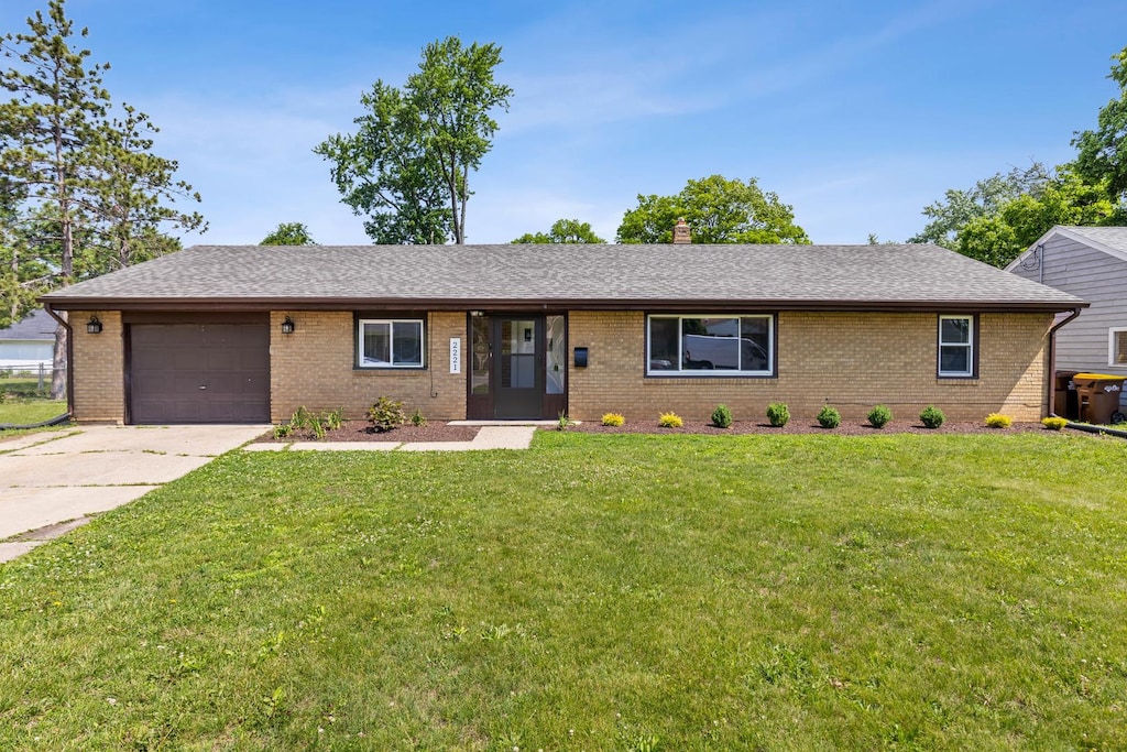 2221 Sharon Ave, Rockford, IL 61103 - ranch-style home with brick siding, a garage, a front lawn, and driveway