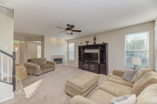 11703 Wolf Creek Ln, Plainfield, IL 60585 - living area featuring ceiling fan, a tile fireplace, light carpet, and stairway