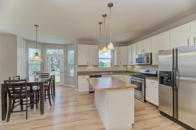 11703 Wolf Creek Ln, Plainfield, IL 60585 - kitchen with stainless steel appliances, light wood-type flooring, a center island, and healthy amount of natural light