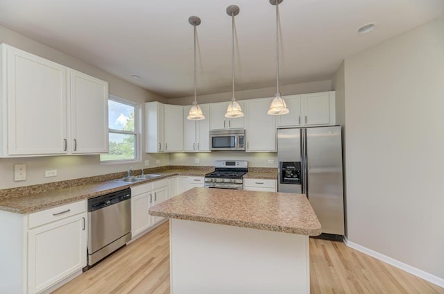 11703 Wolf Creek Ln, Plainfield, IL 60585 - kitchen with appliances with stainless steel finishes, a center island, light wood-style flooring, white cabinetry, and hanging light fixtures