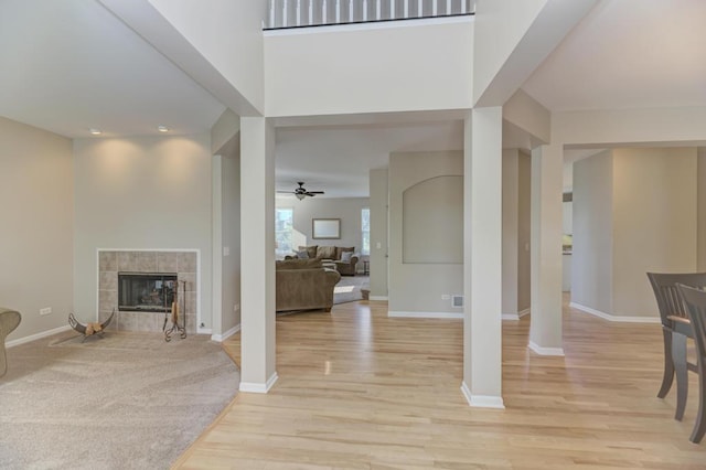 11703 Wolf Creek Ln, Plainfield, IL 60585 - entryway with light wood-type flooring, a tiled fireplace, and a ceiling fan
