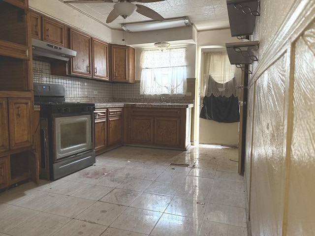 1826 S Kildare Ave, Chicago, IL 60623 - kitchen featuring gas stove, under cabinet range hood, a ceiling fan, decorative backsplash, and brown cabinets