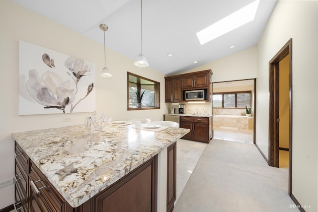 7 Bell Oak Ln, Lemont, IL 60439 - kitchen featuring a skylight, stainless steel microwave, vaulted ceiling, pendant lighting, and dark brown cabinetry