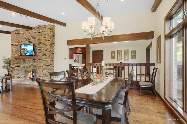 7 Bell Oak Ln, Lemont, IL 60439 - dining room with beamed ceiling, light wood-style floors, a brick fireplace, a chandelier, and a high ceiling