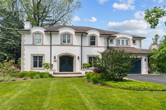 1111 Seneca Rd, Wilmette, IL 60091 - french provincial home featuring a chimney, a front yard, asphalt driveway, french doors, and roof with shingles