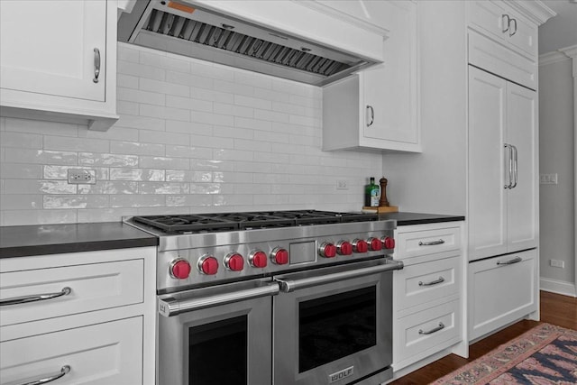 1111 Seneca Rd, Wilmette, IL 60091 - kitchen featuring premium appliances, ventilation hood, dark countertops, decorative backsplash, and white cabinetry