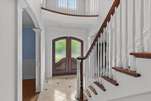 1111 Seneca Rd, Wilmette, IL 60091 - entrance foyer with arched walkways, french doors, crown molding, stairs, and light tile patterned floors