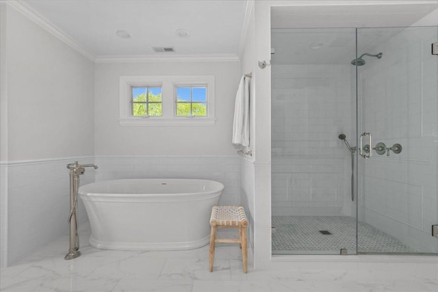 1111 Seneca Rd, Wilmette, IL 60091 - bathroom with marble finish floors, a soaking tub, a shower stall, ornamental molding, and a wainscoted wall