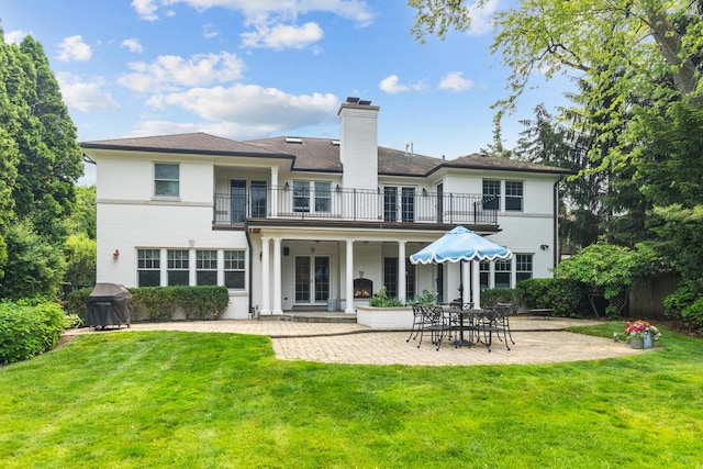 1111 Seneca Rd, Wilmette, IL 60091 - rear view of property with a balcony, a patio area, a yard, a chimney, and french doors
