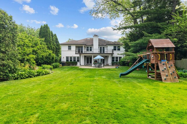 1111 Seneca Rd, Wilmette, IL 60091 - back of house featuring a balcony, a playground, a chimney, and a patio area