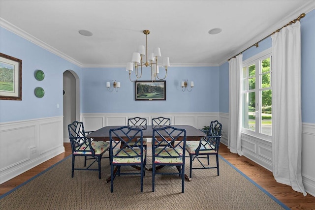 1111 Seneca Rd, Wilmette, IL 60091 - dining area featuring crown molding, arched walkways, a chandelier, wood finished floors, and wainscoting