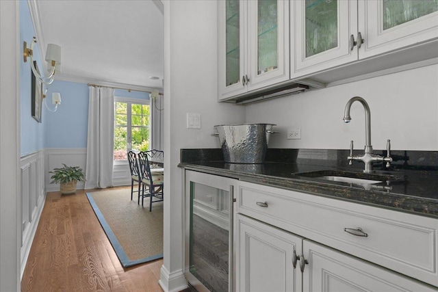 1111 Seneca Rd, Wilmette, IL 60091 - bar area featuring beverage cooler, light wood-style flooring, and a wainscoted wall