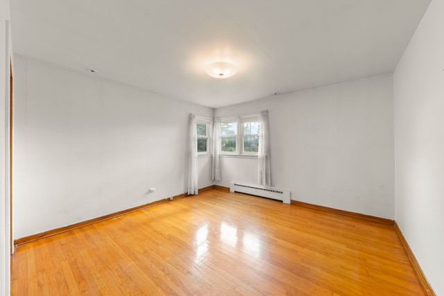 3021 Pearl St, Franklin Park, IL 60131 - unfurnished room with a baseboard heating unit and light wood-style floors