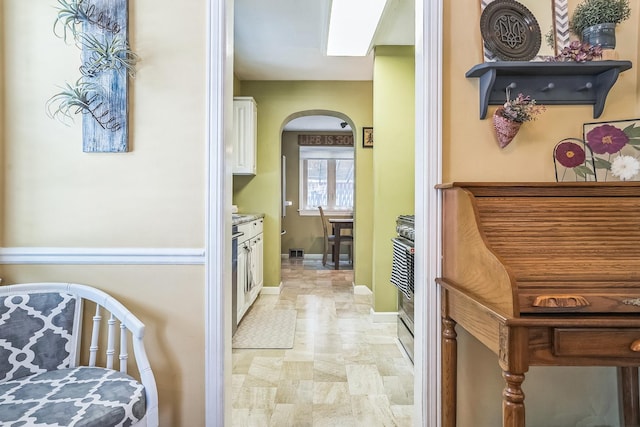 7805 W Farragut Ave, Chicago, IL 60656 - kitchen with arched walkways, white cabinetry, and stainless steel range oven