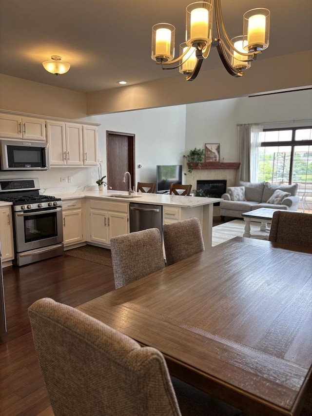 14867 Steven Ct, Lemont, IL 60439 - dining space with a chandelier, a fireplace, dark wood-type flooring, and recessed lighting