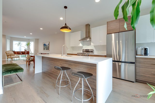 42 Legacy Ln, Wheeling, IL 60090 - kitchen featuring appliances with stainless steel finishes, wall chimney range hood, modern cabinets, light wood-style flooring, and light countertops