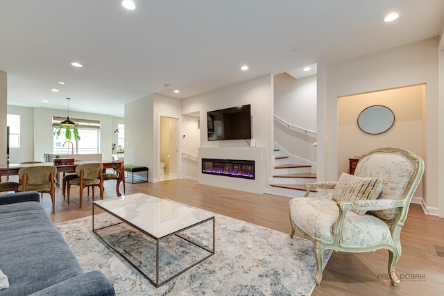 42 Legacy Ln, Wheeling, IL 60090 - living room with recessed lighting, light wood-style floors, stairs, and a glass covered fireplace