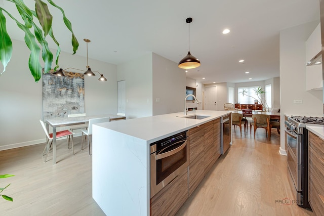 42 Legacy Ln, Wheeling, IL 60090 - kitchen featuring appliances with stainless steel finishes, modern cabinets, light wood finished floors, a center island with sink, and light countertops