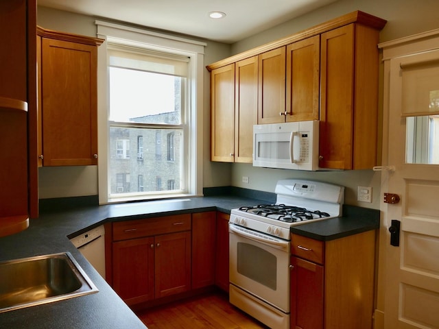 1961 W Winona Ave Unit 3, Chicago, IL 60640 - kitchen featuring white appliances, dark countertops, wood finished floors, brown cabinets, and recessed lighting
