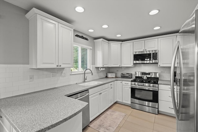 2680 Jenna Cir, Montgomery, IL 60538 - kitchen featuring appliances with stainless steel finishes, a peninsula, white cabinetry, recessed lighting, and tasteful backsplash