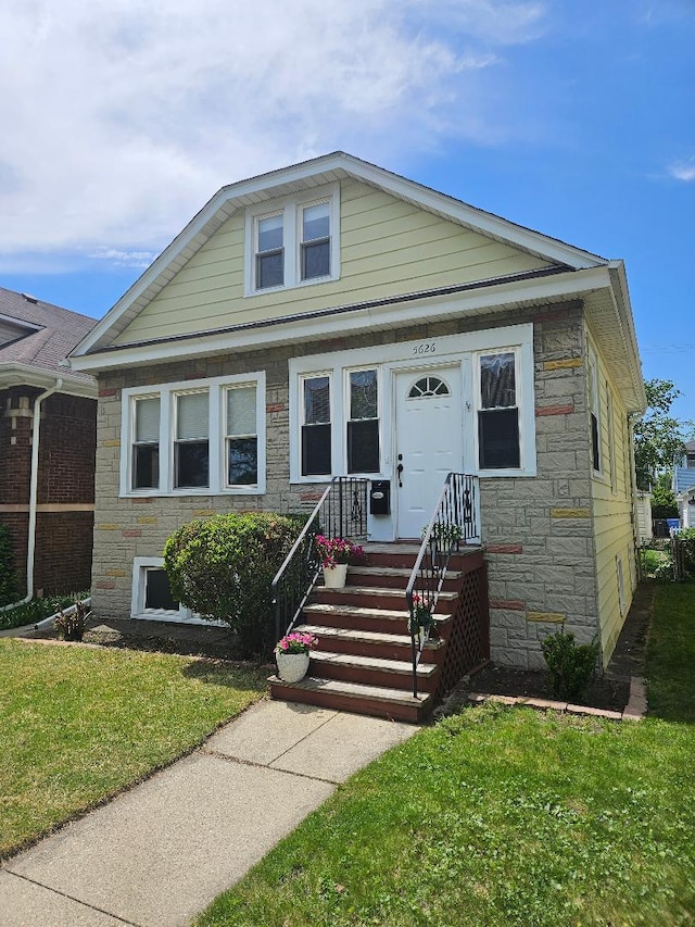 5626 N Mcvicker Ave, Chicago, IL 60646 - view of front facade featuring stone siding and a front lawn