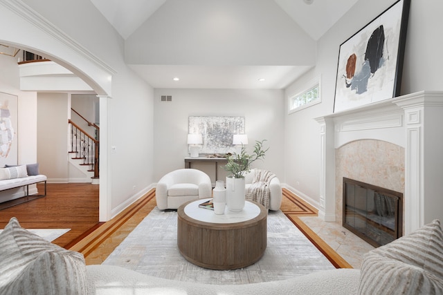 1046 Sylvan Cir, Naperville, IL 60540 - living room with vaulted ceiling, a tiled fireplace, stairway, arched walkways, and recessed lighting