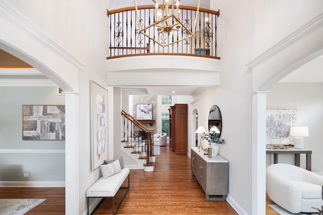 1046 Sylvan Cir, Naperville, IL 60540 - foyer featuring arched walkways, wood finished floors, a high ceiling, a chandelier, and ornate columns