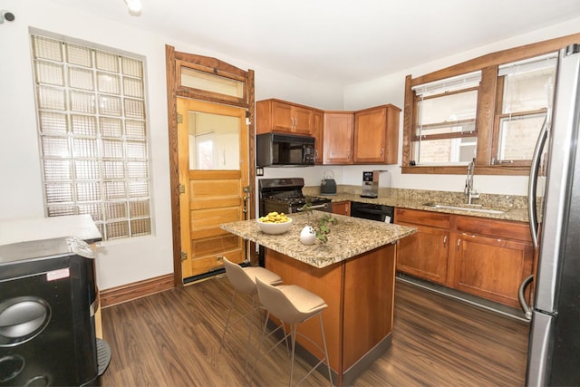 3110 N 78th Ave, Elmwood Park, IL 60707 - kitchen featuring appliances with stainless steel finishes, dark wood finished floors, brown cabinetry, light stone countertops, and a breakfast bar