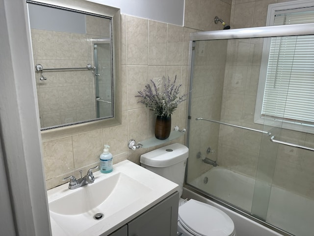 700 Cumberland St, Hoffman Estates, IL 60194 - bathroom featuring tile walls, bath / shower combo with glass door, vanity, and backsplash
