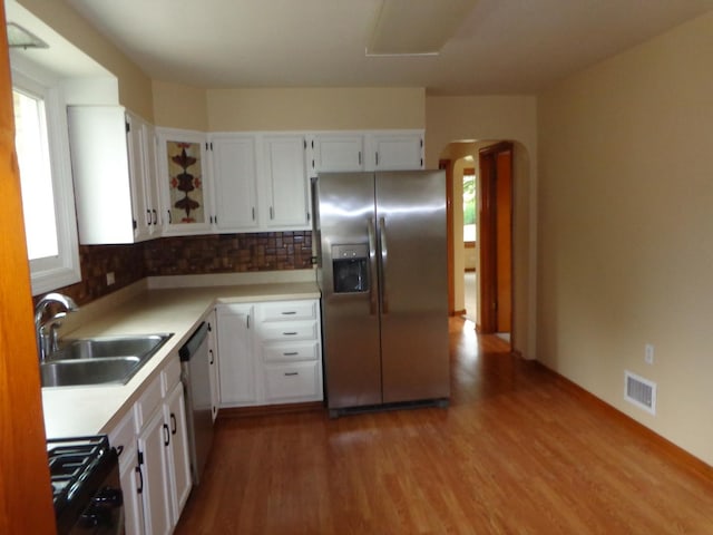 5157 W 90th St, Oak Lawn, IL 60453 - kitchen featuring stainless steel appliances, dark wood finished floors, white cabinetry, arched walkways, and backsplash