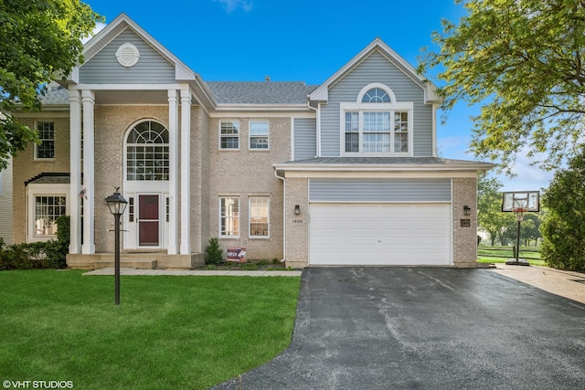 1456 Della Dr, Hoffman Estates, IL 60169 - greek revival inspired property featuring brick siding, a front yard, and driveway