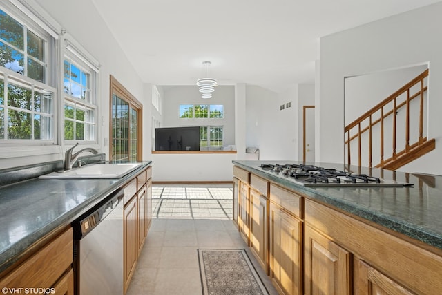 1456 Della Dr, Hoffman Estates, IL 60169 - kitchen with dishwashing machine, stainless steel gas cooktop, brown cabinets, light tile patterned floors, and pendant lighting