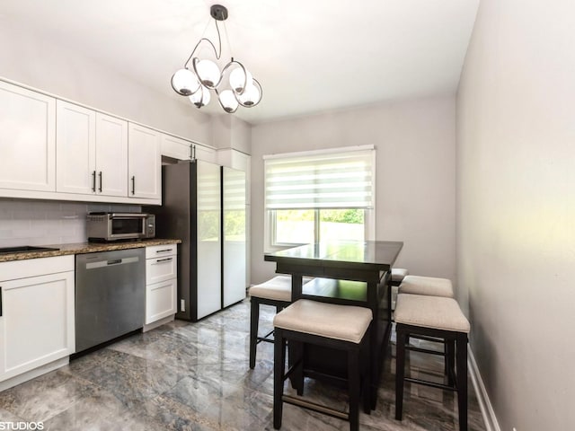 1022 Pinetree Cir N Unit 1022, Buffalo Grove, IL 60089 - kitchen with appliances with stainless steel finishes, tasteful backsplash, white cabinets, a chandelier, and decorative light fixtures