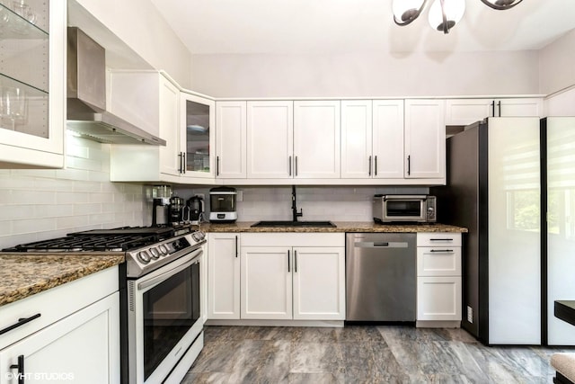 1022 Pinetree Cir N Unit 1022, Buffalo Grove, IL 60089 - kitchen with stainless steel appliances, wall chimney exhaust hood, white cabinets, backsplash, and dark stone counters
