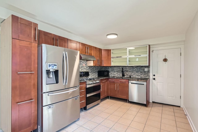 2067 W Farwell Ave Unit 1S, Chicago, IL 60645 - kitchen with stainless steel appliances, under cabinet range hood, decorative backsplash, light tile patterned floors, and glass insert cabinets