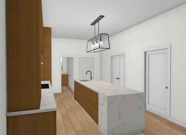 1143 Clinton Ave, Oak Park, IL 60304 - kitchen featuring light wood-style floors, pendant lighting, an island with sink, light stone countertops, and modern cabinets