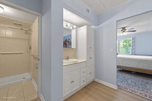 1301 N Western Ave Unit 317, Lake Forest, IL 60045 - ensuite bathroom featuring ceiling fan, vanity, crown molding, tiled shower, and wood finished floors